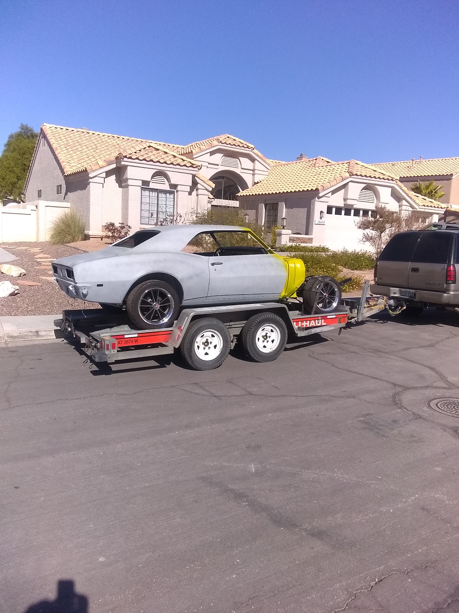 Classic Camaro project car in primer loaded on a U-Haul trailer